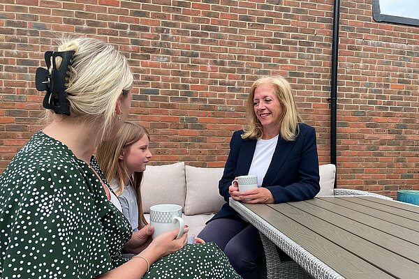 Liz speaks to a mum and daughter in garden