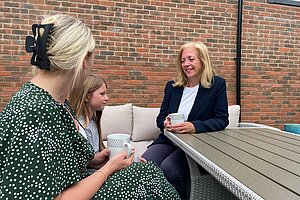 Liz with a mother and daughter sat in a garden