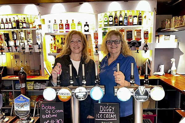 Liz pulling a pint with local pub landlady