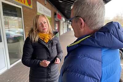 Liz talking to man in street